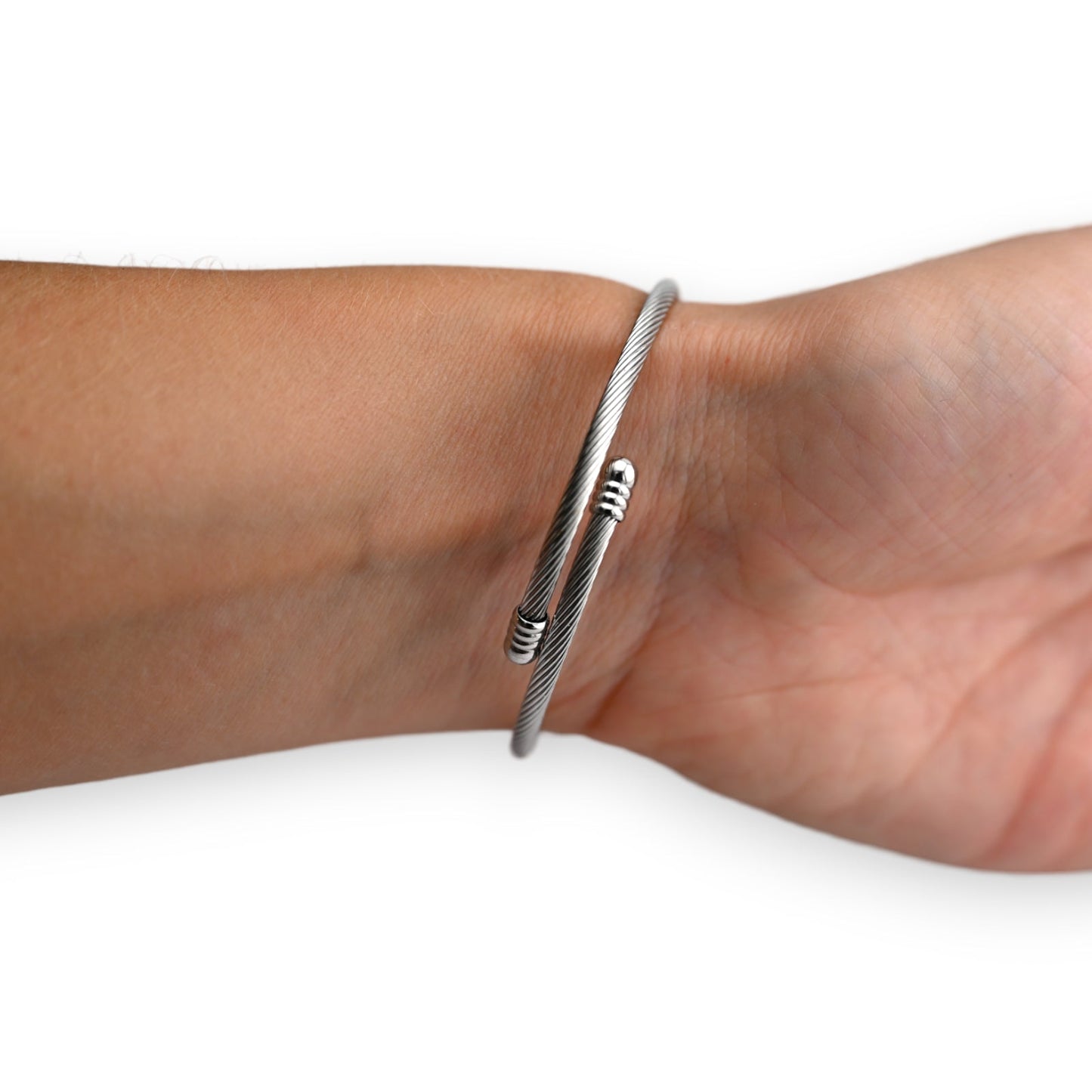 Silbernes Kabelarmband um ein Handgelenk, minimalistisches Design mit spiralförmigem Verschluss, modern und elegant