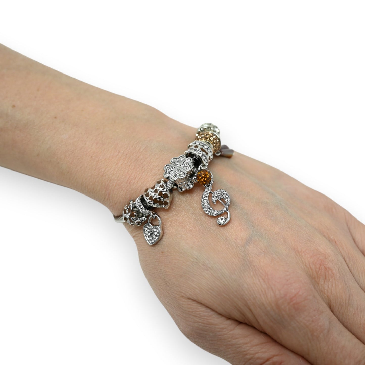 Silbernes Charm-Armband mit verschiedenen Anhängern, darunter eine Musiknote, Herzen und Blumen, auf einem Handgelenk