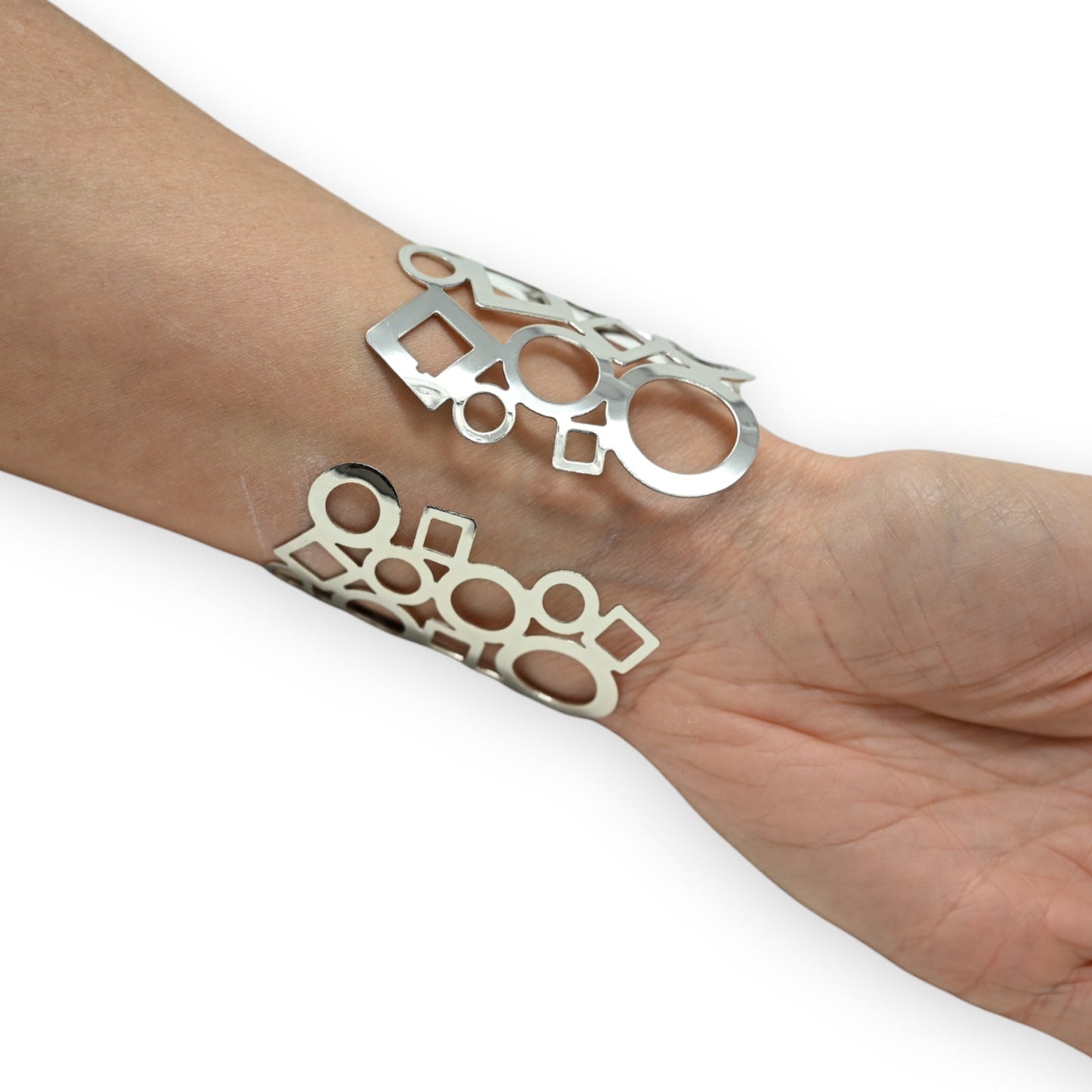 Silbernes Armband mit geometrischem Muster aus Kreisen und Quadraten auf Handgelenk, moderner Schmuck