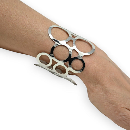 Silbernes Metallarmband mit rundem Lochmuster auf Handgelenk, moderner Schmuck-Accessoire mit geometrischem Design