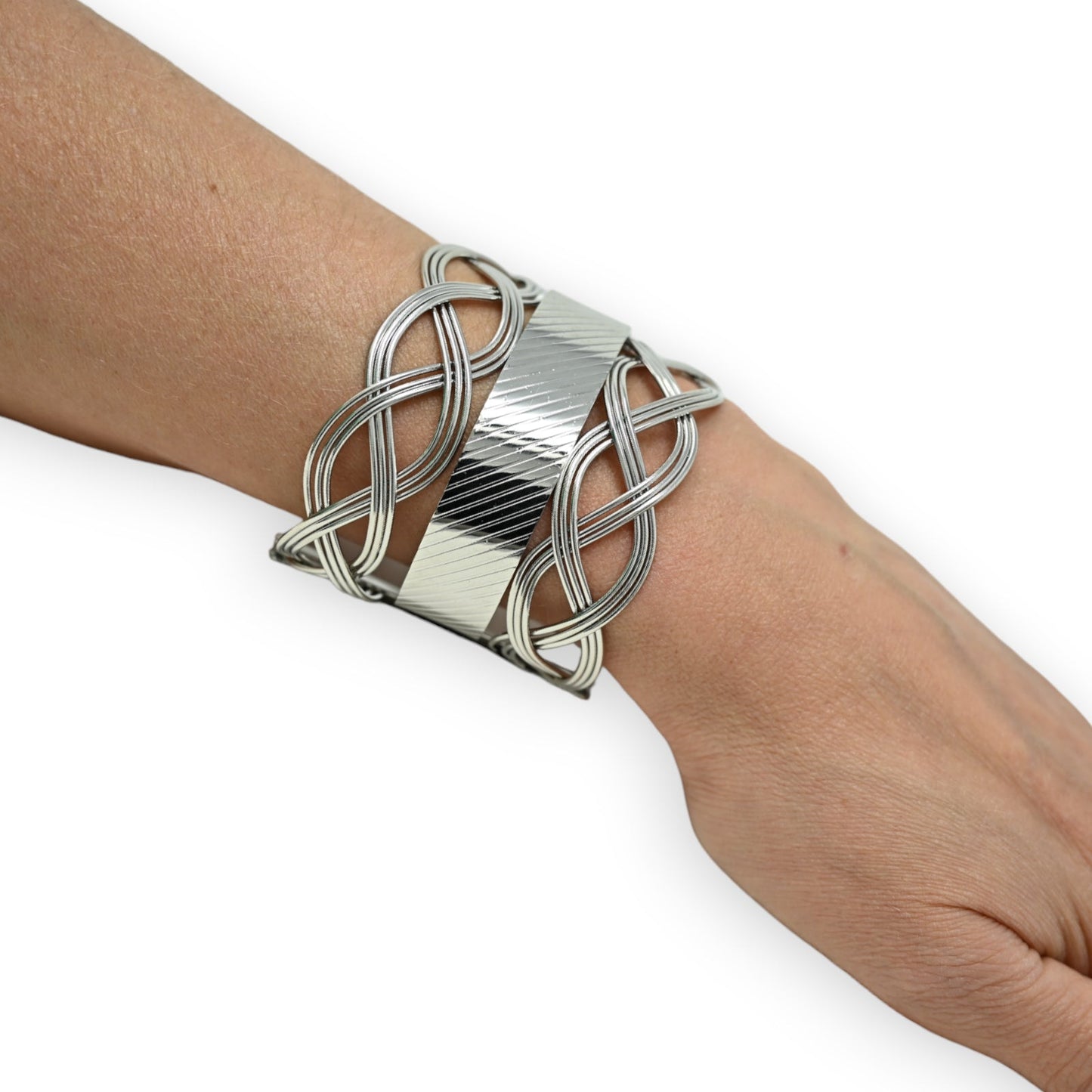 Elegantes silbernes Manschettenarmband mit verschlungenen Linien und geometrischem Design auf Handgelenk