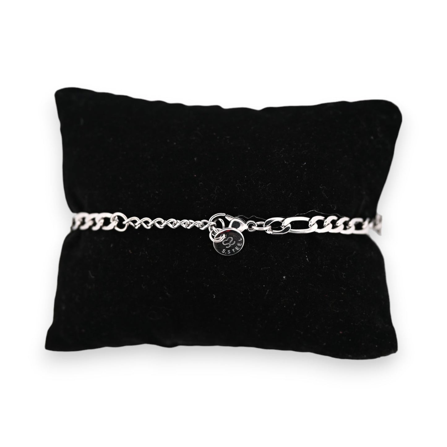 Silbernes Stahlarmband auf schwarzem Samtkissen, mit feiner Kettengliederung und rundem Anhänger