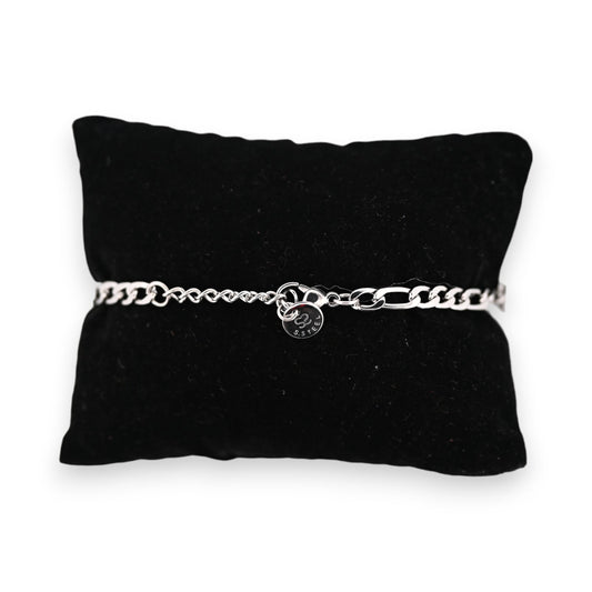 Silbernes Stahlarmband auf schwarzem Samtkissen, mit feiner Kettengliederung und rundem Anhänger