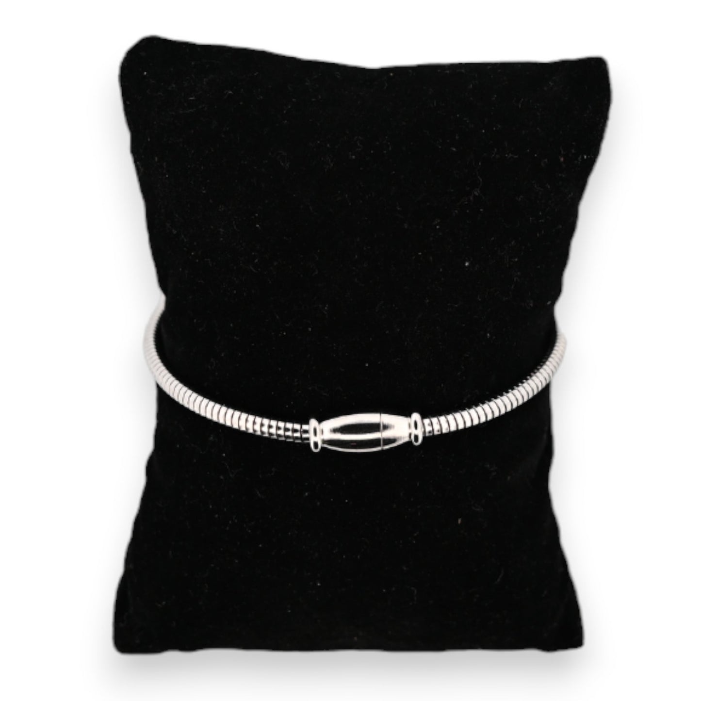 Silberfarbenes Stahlarmband auf schwarzem Samtkissen, mit eleganter länglicher Schließe als zentrales Element