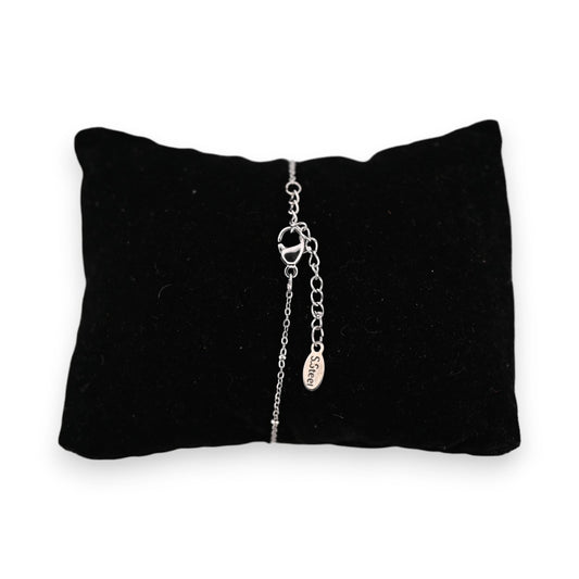 Silberfarbenes Stahlarmband auf schwarzem Kissen, feines Kettendesign mit perlmuttfarbenem Halbmond-Anhänger und S.Steel-E...