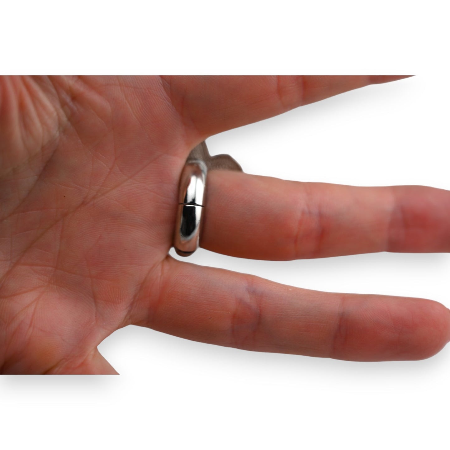 Silberner Ehering am Ringfinger einer Hand, nahaufnahme auf weißem Hintergrund, glänzende Oberfläche