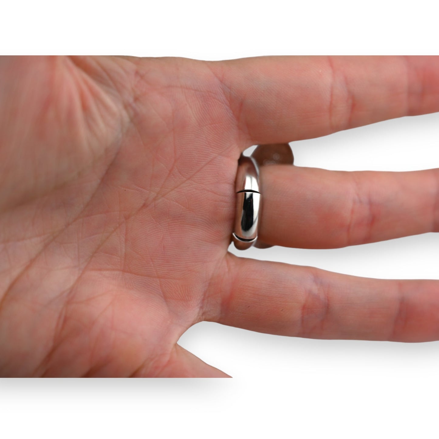 Glatter silberner Ring an einem Finger, Nahaufnahme der Handfläche und Fingerlinien sichtbar