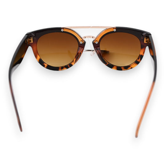 Stylische Sonnenbrille mit braun getönten Gläsern, Schildpattmuster und goldenem Brückensteg auf weißem Hintergrund