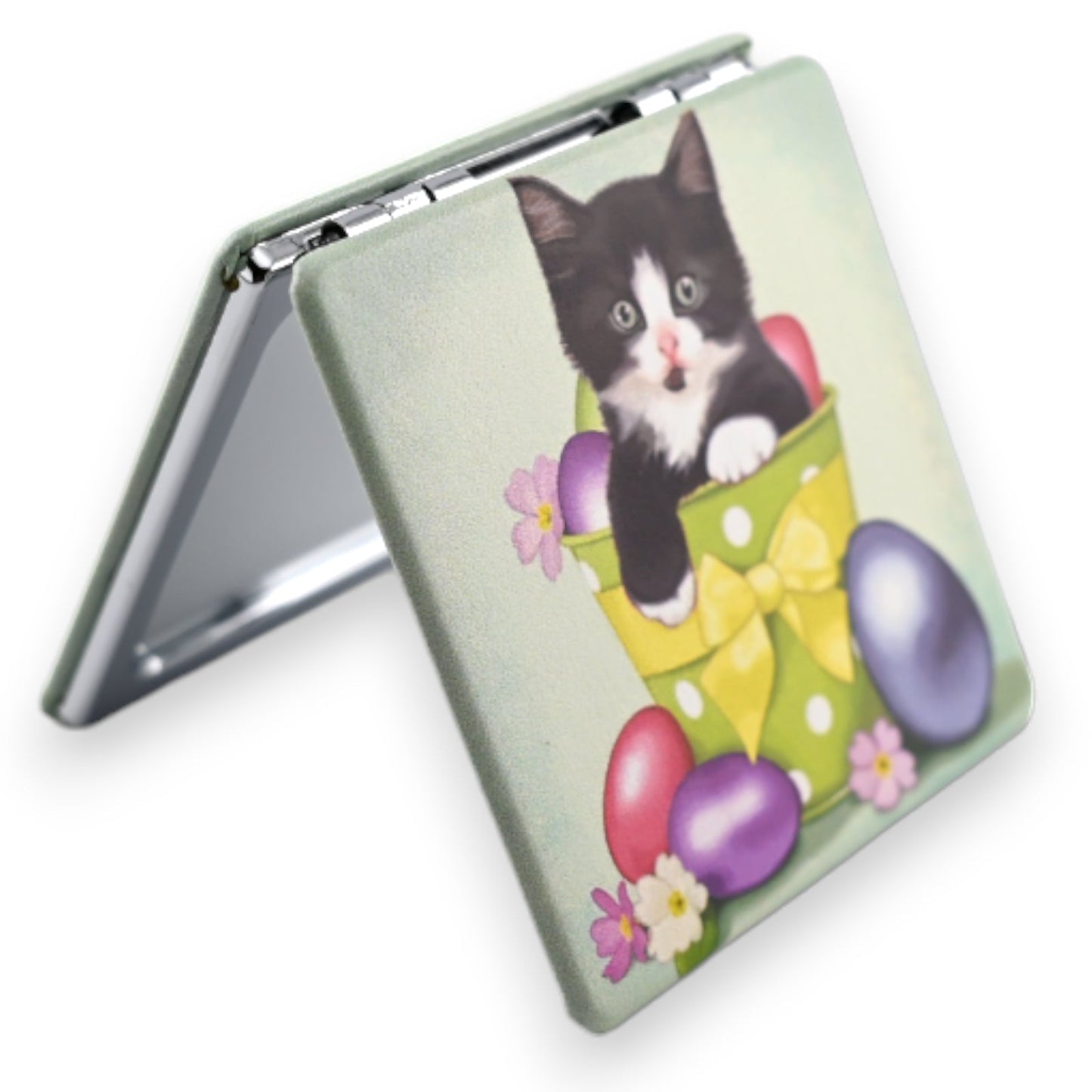 Taschenspiegel mit Motiv: Schwarzweißes Kätzchen in grünem Topf mit gelber Schleife, umgeben von bunten Eiern und Blumen