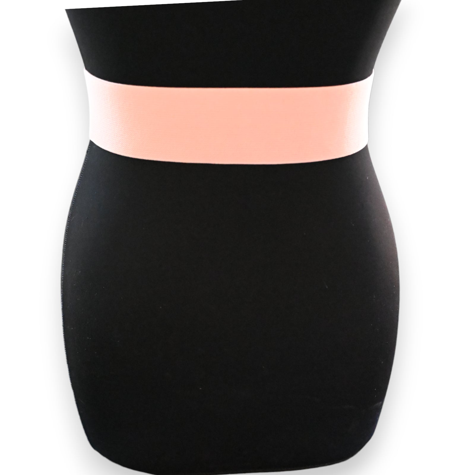 Eleganter elastischer Damengürtel in Altrosa auf schwarzem Kleid, breites Band für modischen Akzent an der Taille