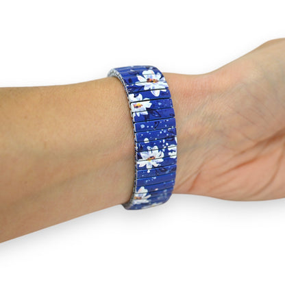 Elegantes Armband mit blauem Blumenmuster, weiße Blüten auf blauem Hintergrund, auf Handgelenk getragen