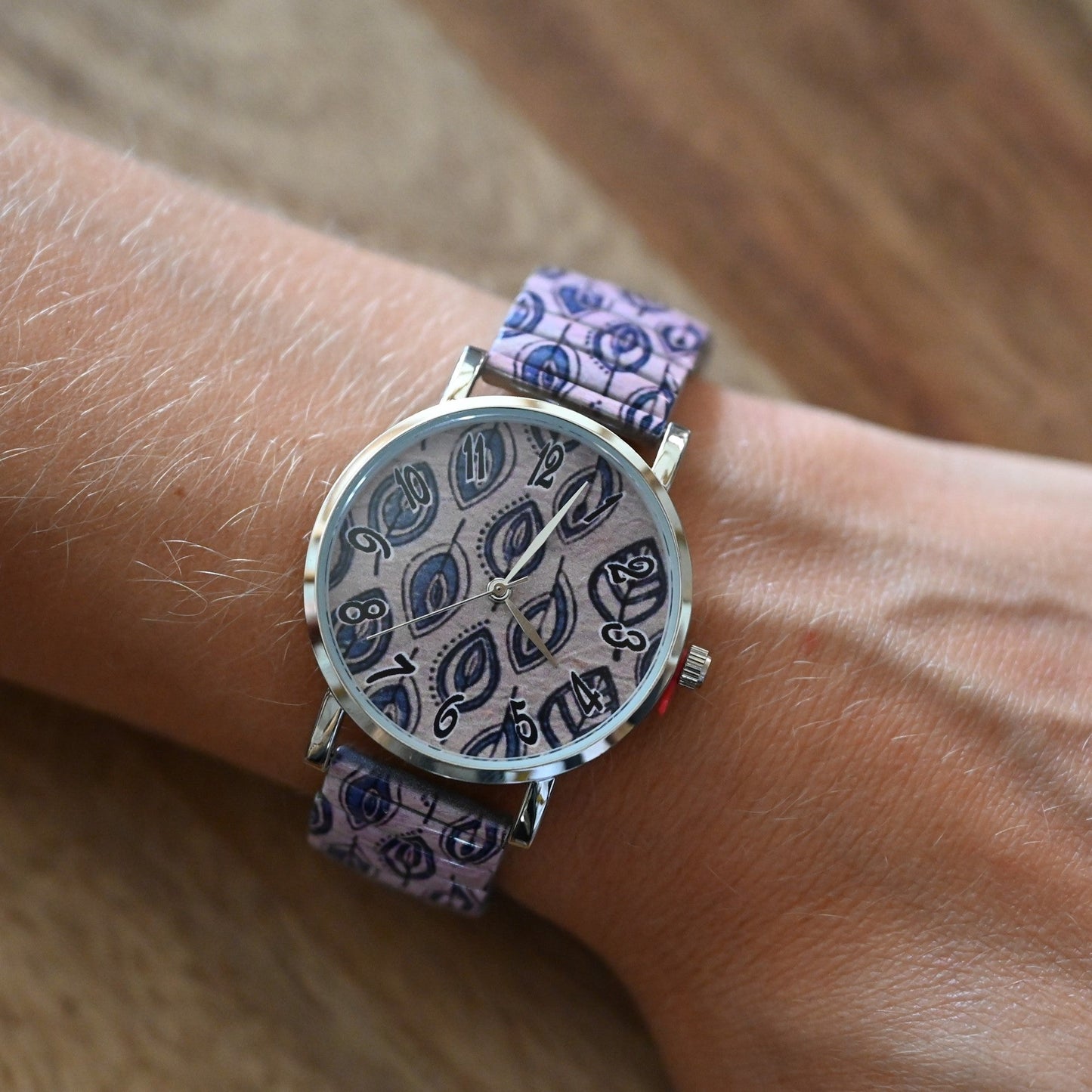 Ernests Uhr mit blauen Blättern auf rosa Hintergrund gedruckt