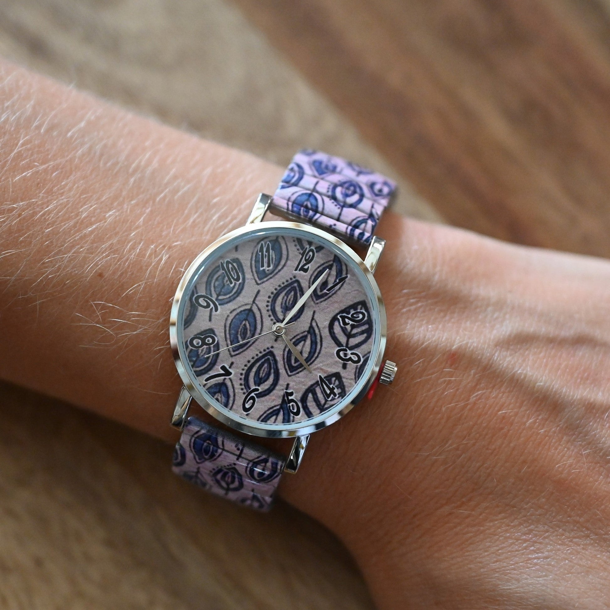 Ernests Uhr mit blauen Blättern auf rosa Hintergrund gedruckt