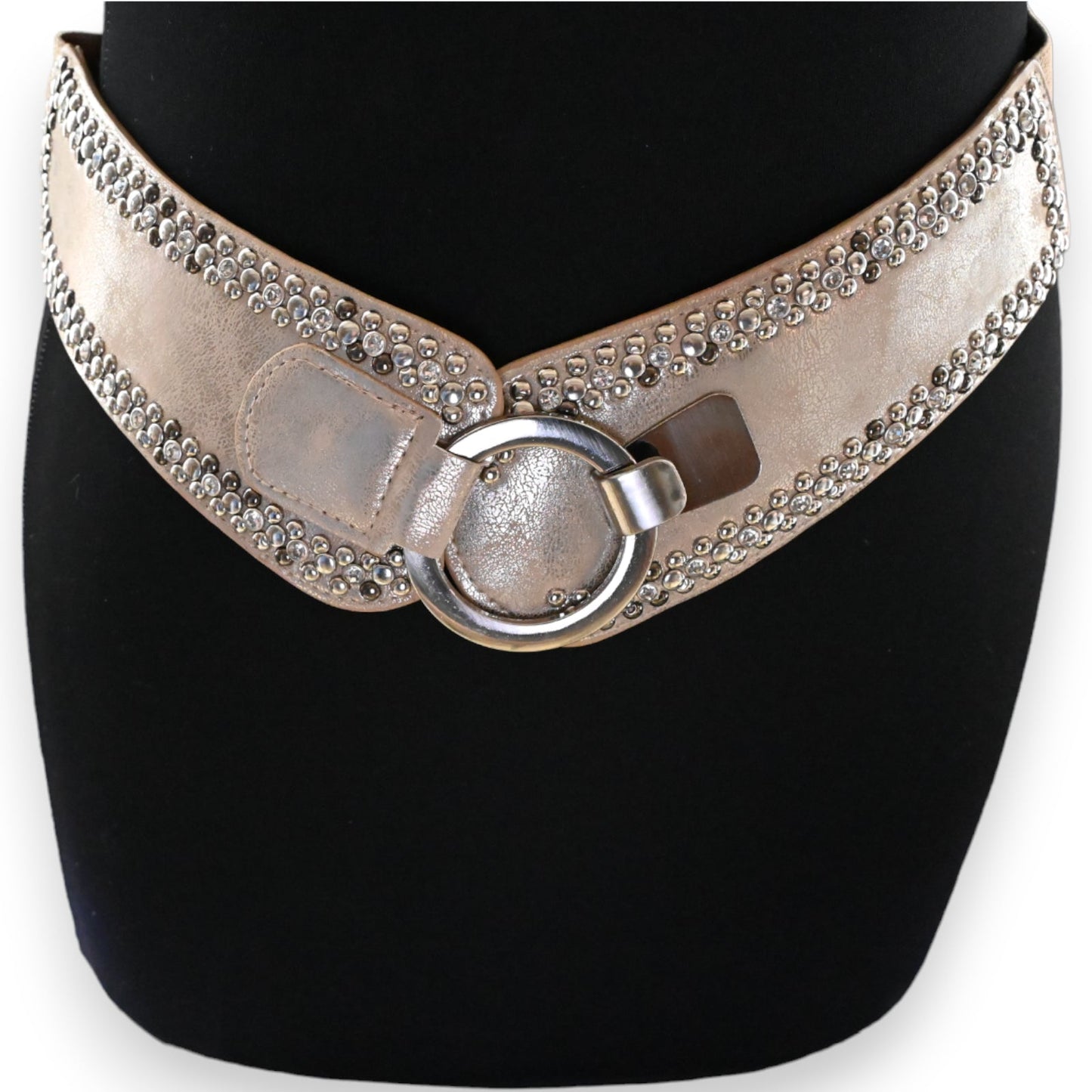 Eleganter beige-goldener Damengürtel mit Nieten und Ringverschluss auf schwarzem Hintergrund, glamouröses Accessoire