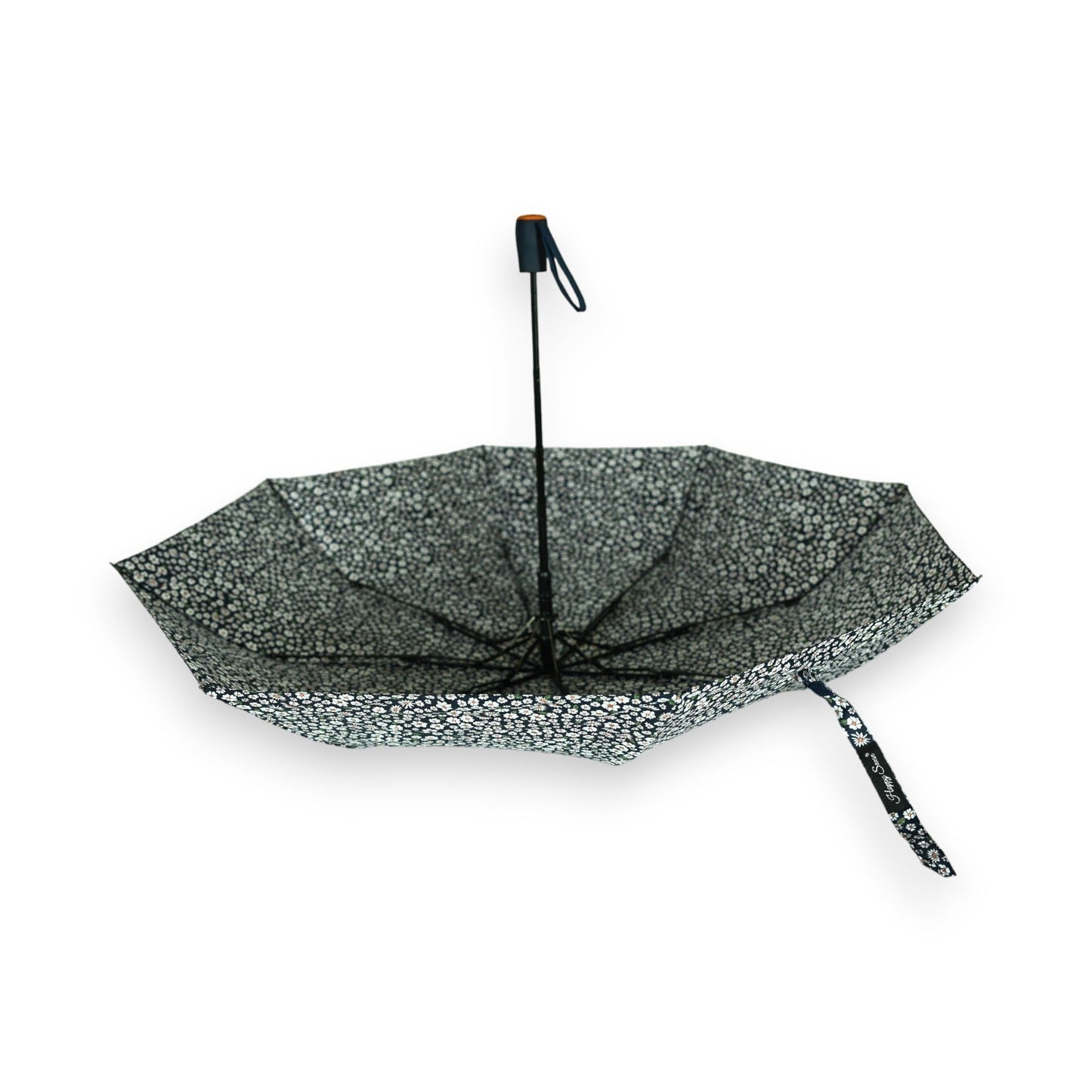 Halbautomatischer Regenschirm mit schwarz-weißem Blumenmuster, zusammengeklappt auf weißem Hintergrund