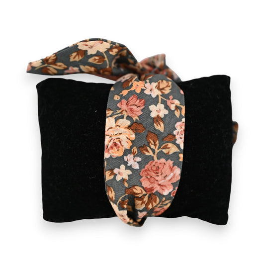 Schwarzes Stoffarmband mit floraler Schleife in Rosatönen auf dunklem Grund, Vintage-Stil, elegantes Accessoire