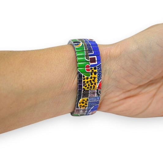 Bunte Patchwork-Armbanduhr mit elastischem Armband am Handgelenk, leuchtende Farben und Muster in Grün, Blau, Gelb und Rot