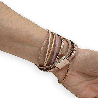 Mehrschichtiges Armband in Rosatönen mit Lederstreifen, Metallketten und Magnetverschluss um ein Handgelenk gewickelt