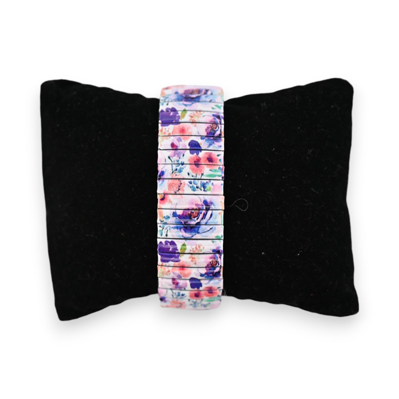 Elastische Armbanduhr mit buntem Blumenmuster auf schwarzem Samtkissen, perfekt für den Frühling und Sommer
