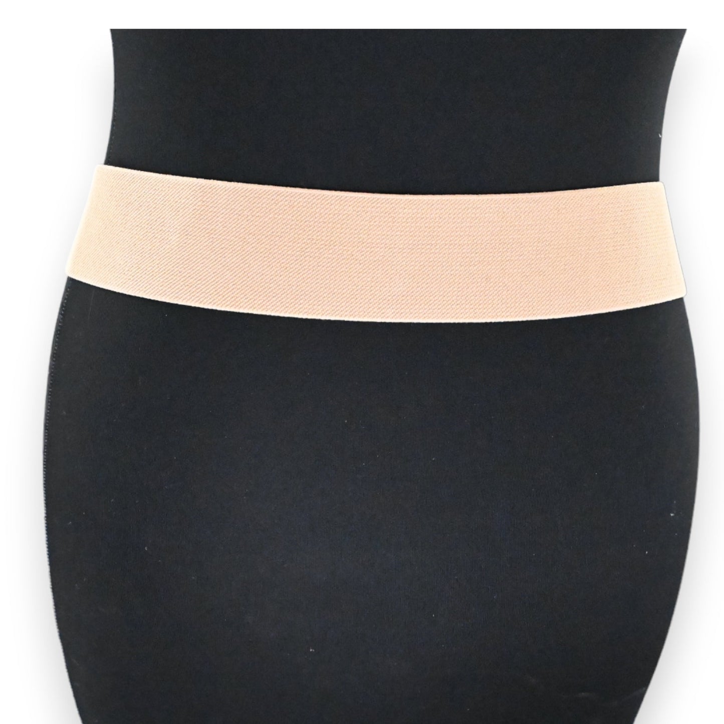 Elastischer Damen-Gürtel in Beige-Gold, schmal und dehnbar, auf schwarzem Hintergrund präsentiert. Modisches Accessoire.