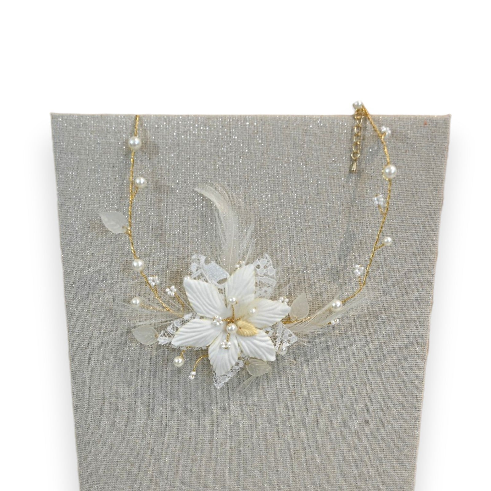 Elegante Elfenbein-Halskette mit Blumenanhänger, Perlen und goldener Kette auf grauem Hintergrund