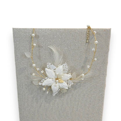Elegante Elfenbein-Halskette mit Blumenanhänger, Perlen und goldener Kette auf grauem Hintergrund