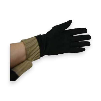 Eleganter schwarzer Handschuh mit taupefarbenem Strickbündchen, getragen an einer Hand vor weißem Hintergrund
