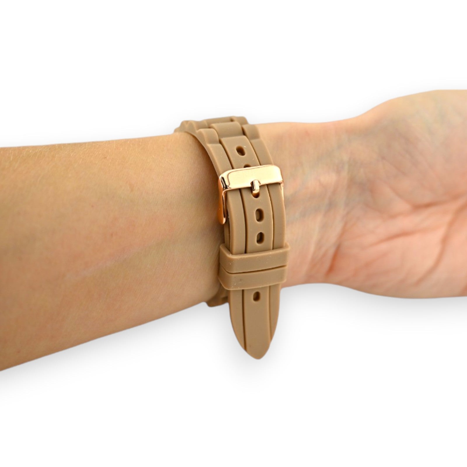 Camelbraunes Silikonarmband einer Uhr am Handgelenk, mit goldener Schnalle und Löchern für Verstellbarkeit