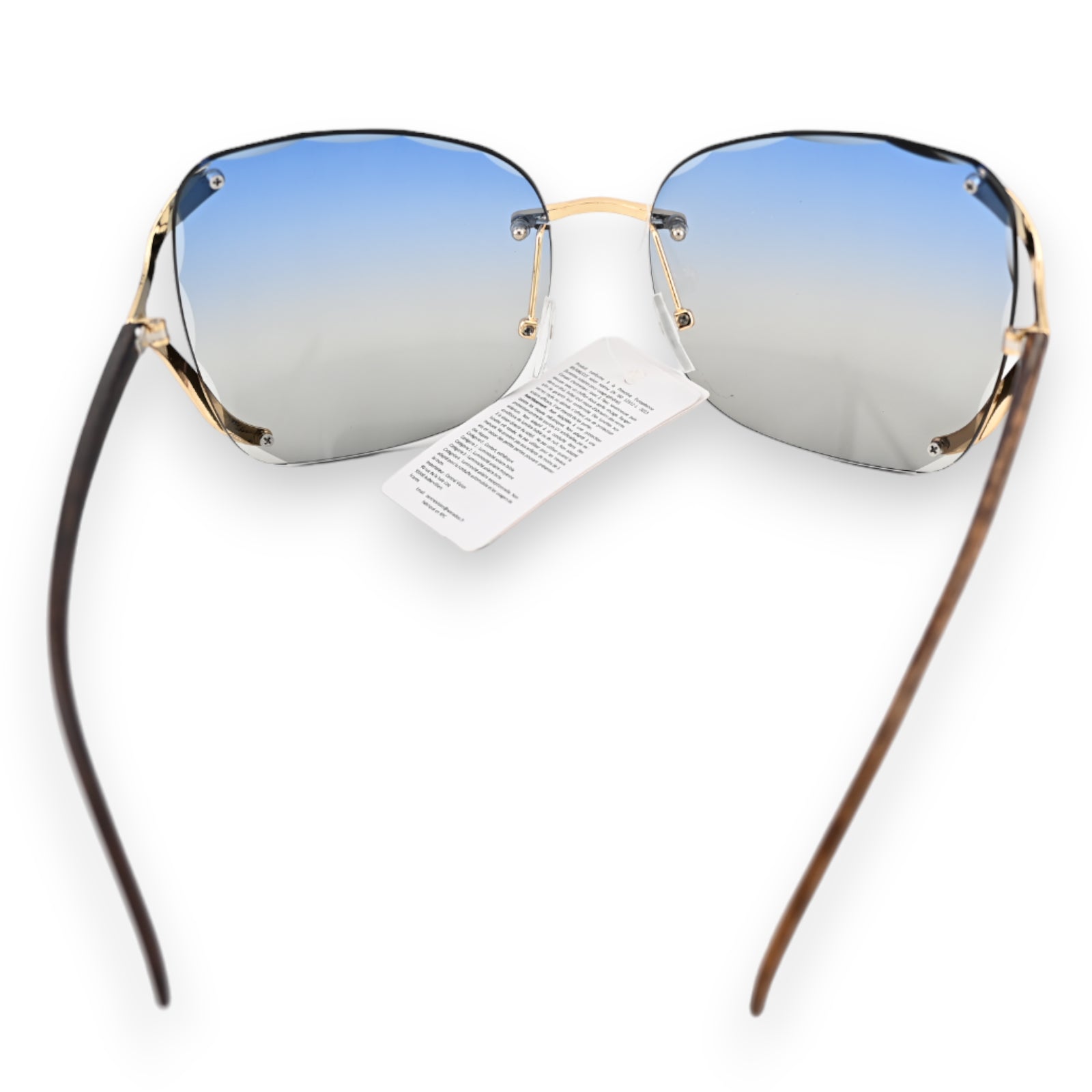 Moderne Sonnenbrille mit blau-grau verlaufenden Gläsern, goldenem Rahmen und dunklen Bügeln, Produktetikett sichtbar