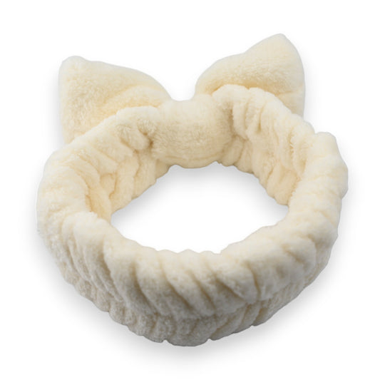 Weiches, flauschiges Stirnband in Ecru mit Katzenohren-Design für Make-up und Haarpflege, auf weißem Hintergrund