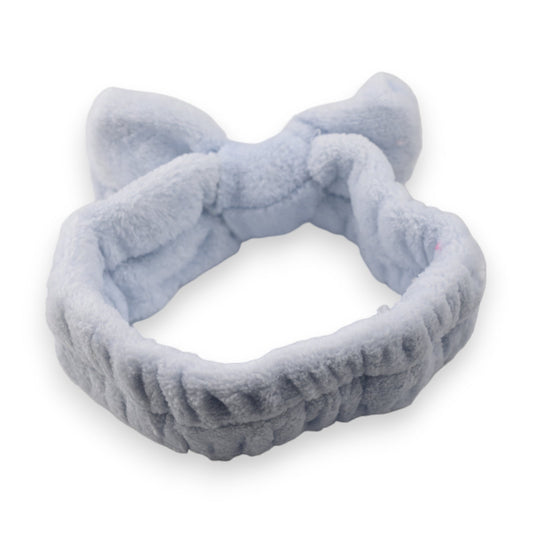 Flauschiges hellblaues Stirnband mit Katzenohren für Make-up und Gesichtspflege, auf weißem Hintergrund