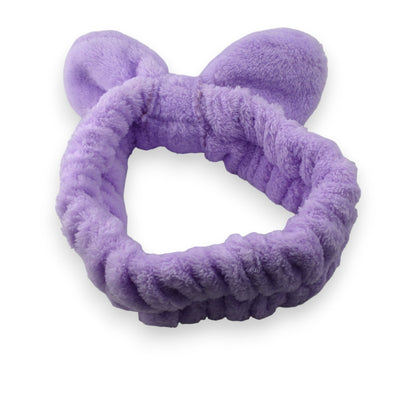 Flauschiges lila Stirnband mit Schleife für Make-up und Haarpflege, weich und elastisch, auf weißem Hintergrund
