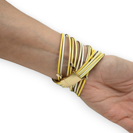 Modernes Armband mit gelben und weißen Lederstreifen, die sich überkreuzen und um ein goldenes Rechteck gewickelt sind