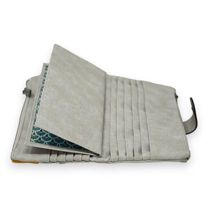 Elegante graue Geldbörse mit mehreren Kartenfächern, geöffnet zeigt blaues Innenfutter mit Fächermuster, Reißverschluss