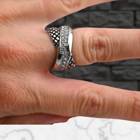 Silberner Stahlring mit Diamantverzierung und schwarzer Textur im Hintergrund