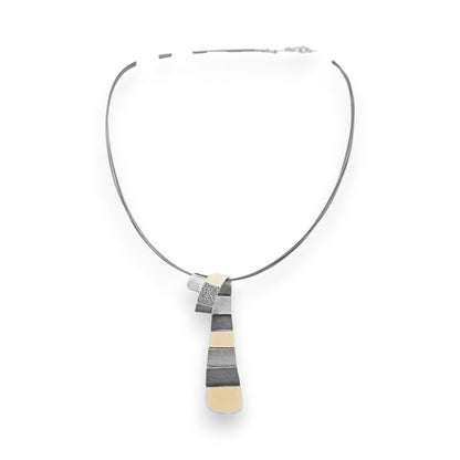 Moderne geometrische Halskette mit grau-beigem Anhänger, filigrane Metallarbeit auf schlichtem Reif, elegantes Design