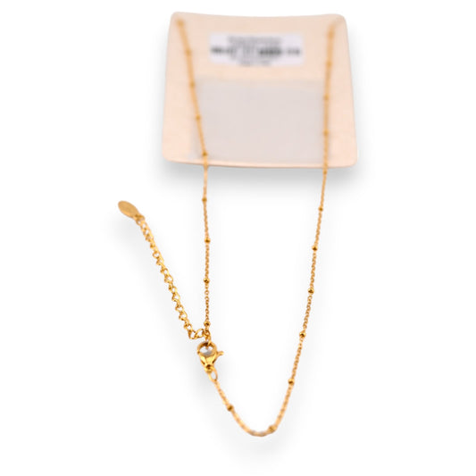 Filigrane goldene Halskette mit feiner Kette und Verschluss auf cremefarbenem Schmuckkärtchen, Nahaufnahme