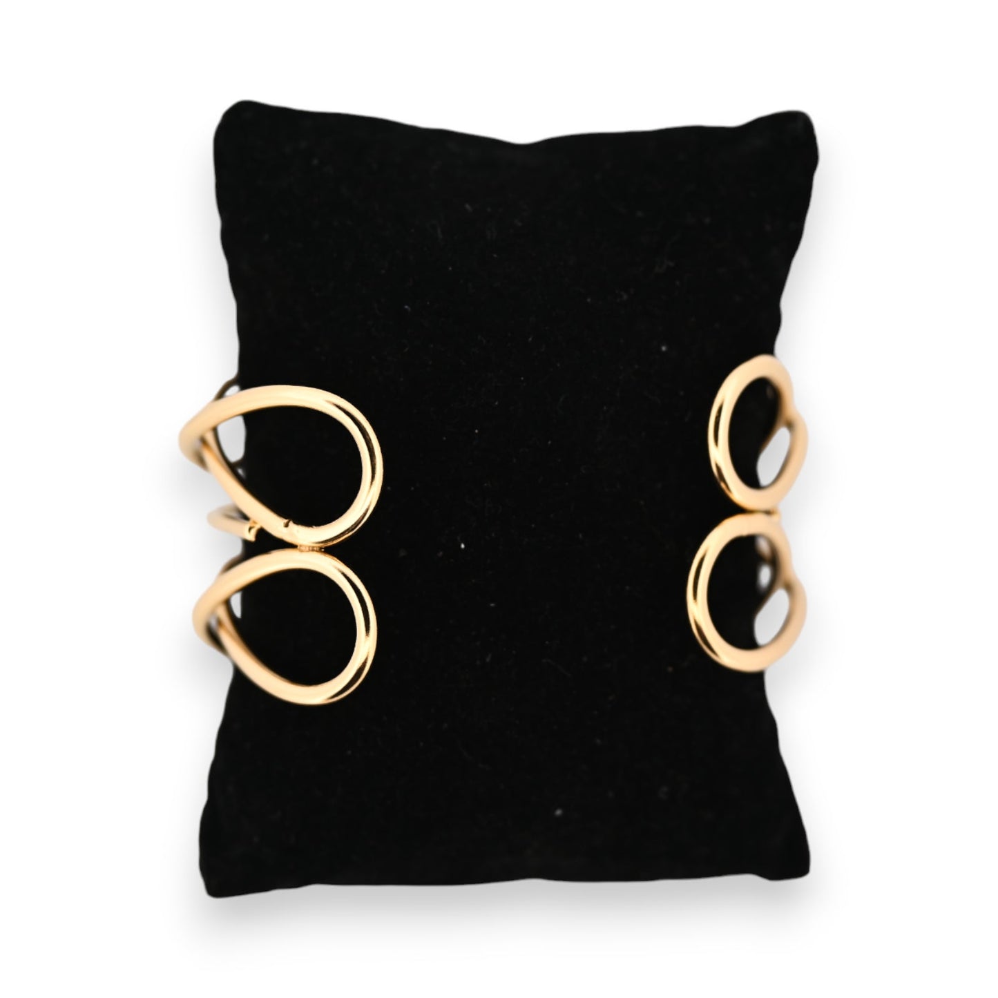 Goldenes Armband mit zwei kreisförmigen Elementen auf schwarzem Hintergrund, minimalistisches Design