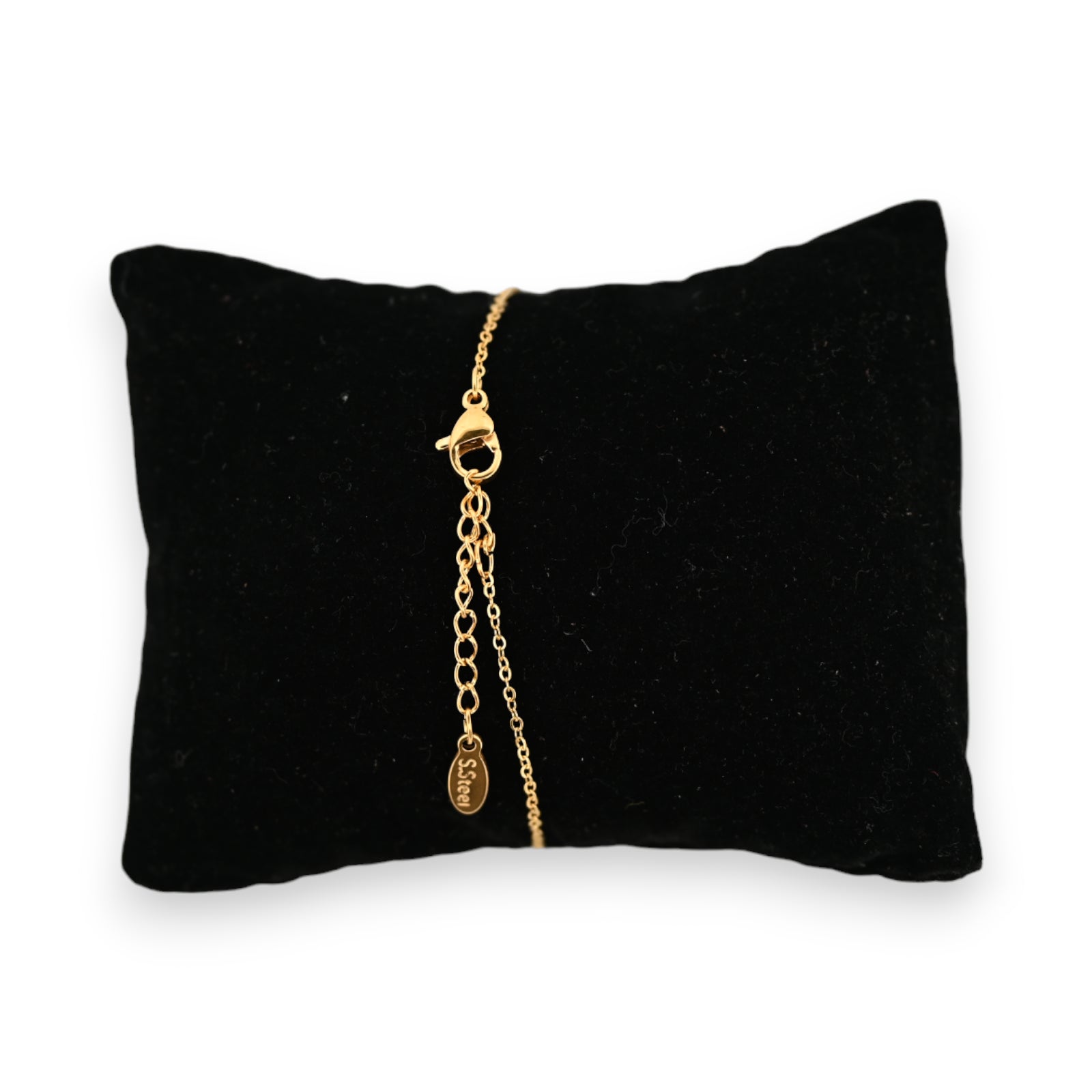 Goldenes Stahlarmband auf schwarzem Samtkissen, mit rundem Anhänger und Sterngravur, elegantes Schmuckstück