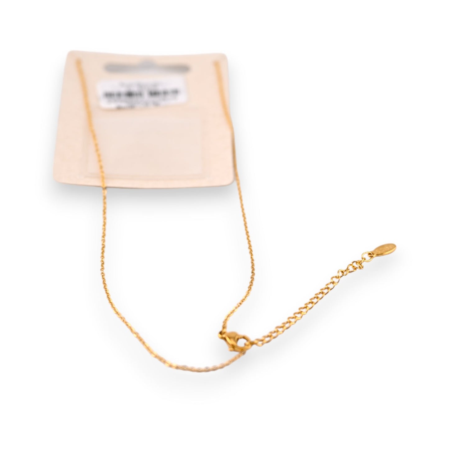 Feines goldenes Stahlhalsband mit Anhänger auf cremefarbener Verpackung, elegantes Schmuckstück für Damen