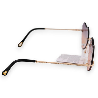 Hippie-Herz-Sonnenbrille mit goldenen Bügeln und braun verlaufenden Gläsern, seitliche Ansicht auf weißem Hintergrund