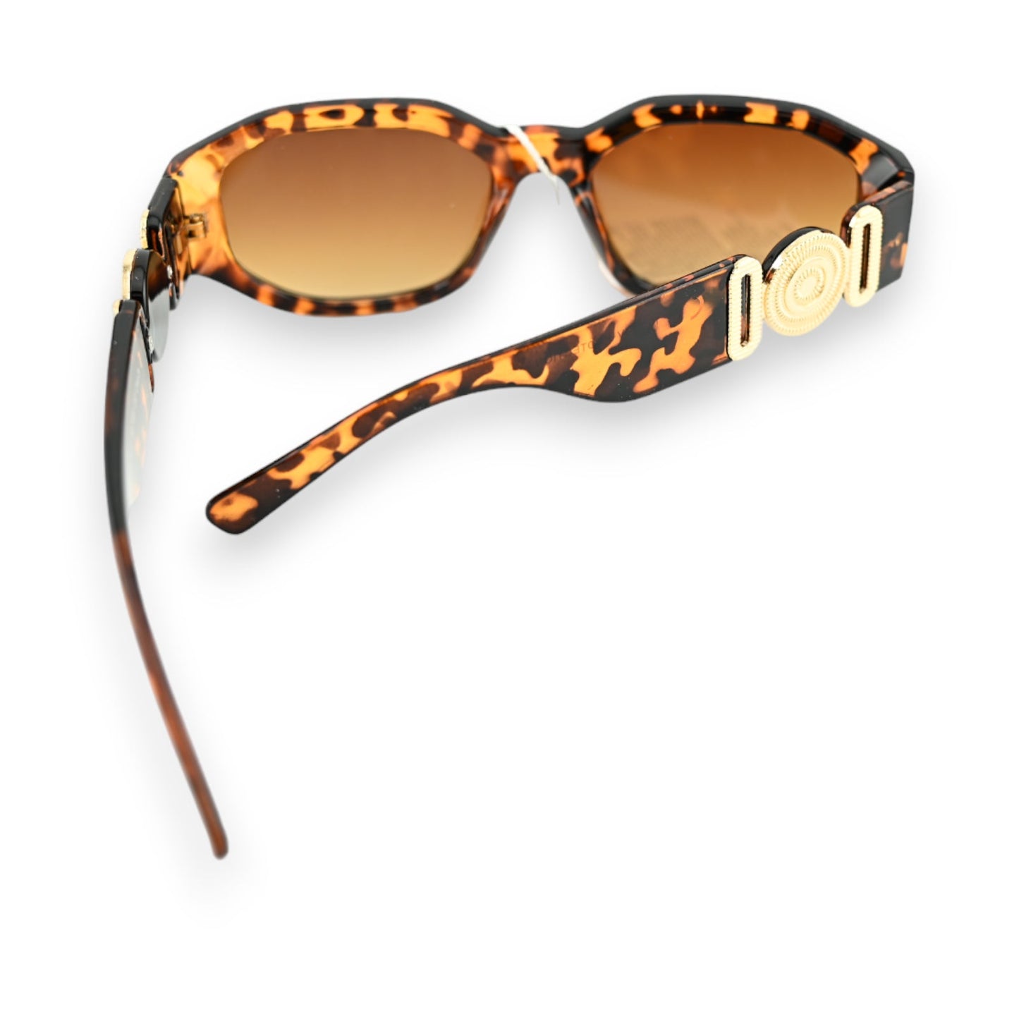 Rechteckige Sonnenbrille mit Leopardenmuster, braunen Bügeln und goldenen Schmuckstücken auf weißem Hintergrund