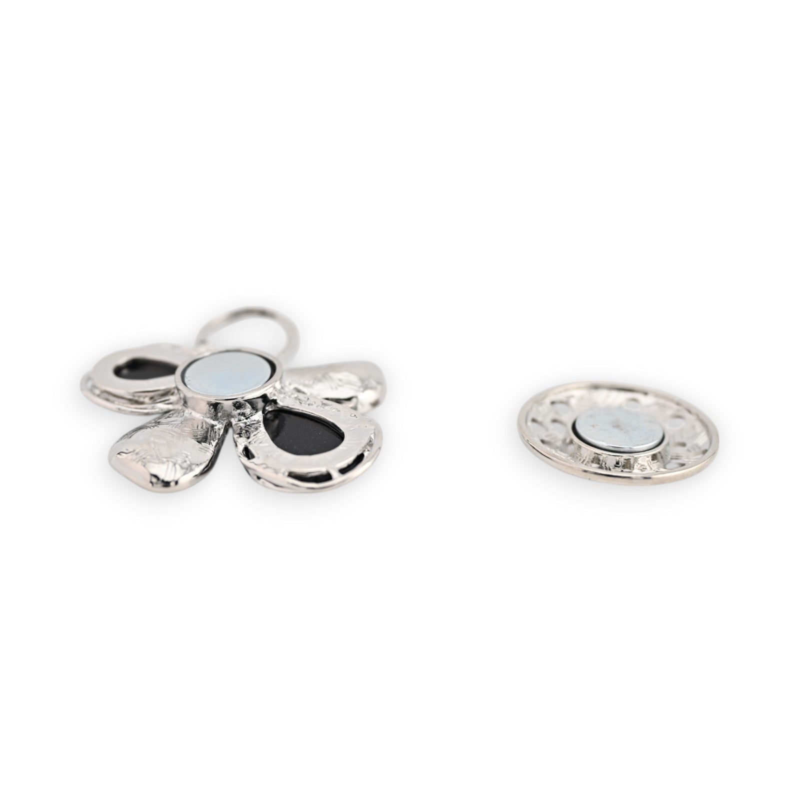Magnetische Blumenbrosche in Silber mit schwarzen Akzenten, fünfblättrig, neben einer runden Magnetscheibe