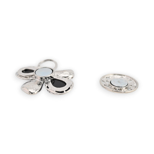Magnetische Blumenbrosche in Silber mit schwarzen Akzenten, fünfblättrig, neben einer runden Magnetscheibe