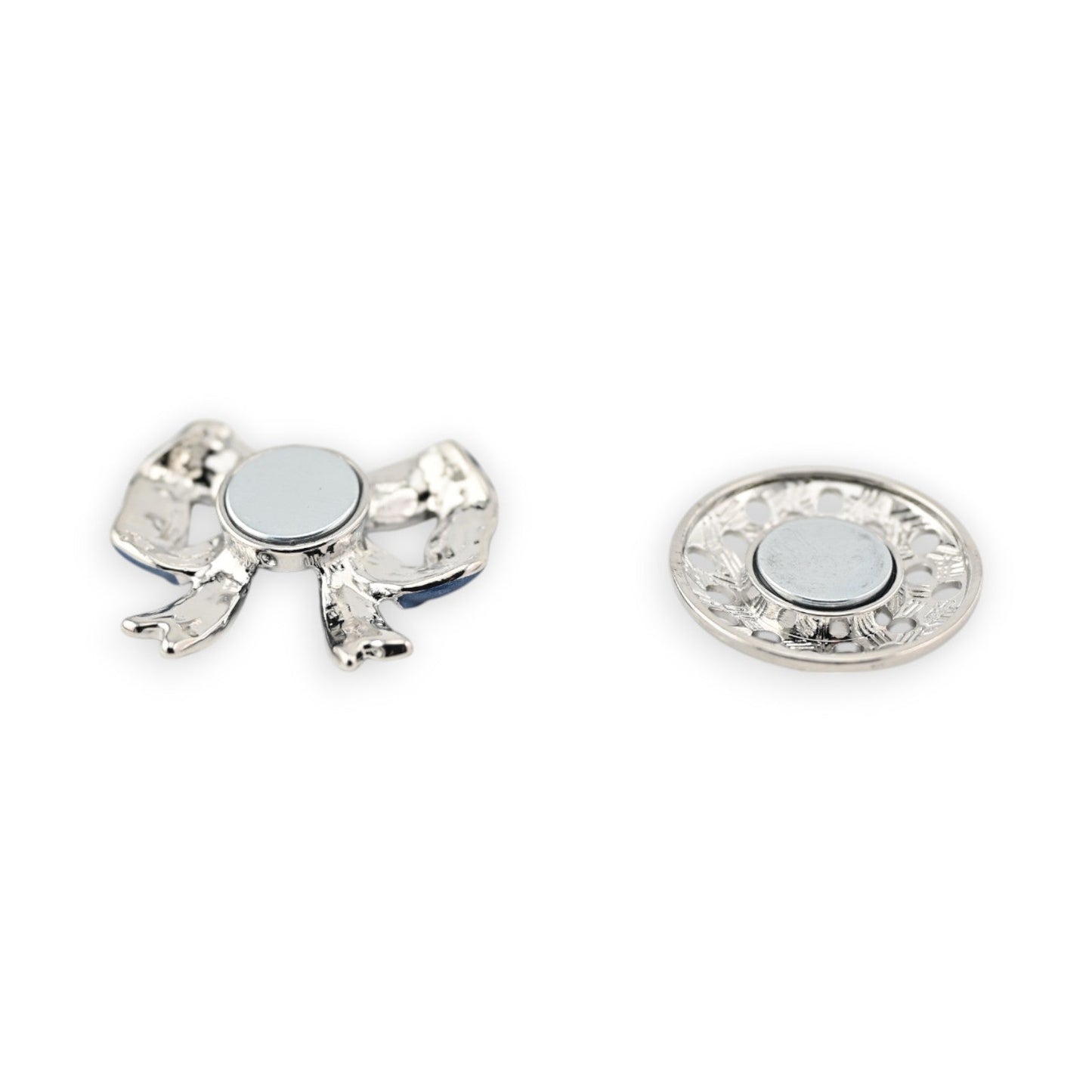 Magnetische Brosche mit silberfarbigem Schmetterling und rundem Magnet, daneben dekorative Magnetplatte mit Blumenmuster