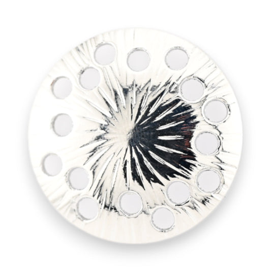 Runde magnetische Brosche mit schwarzem Sternmuster auf silbernem Hintergrund und mehreren Löchern am Rand