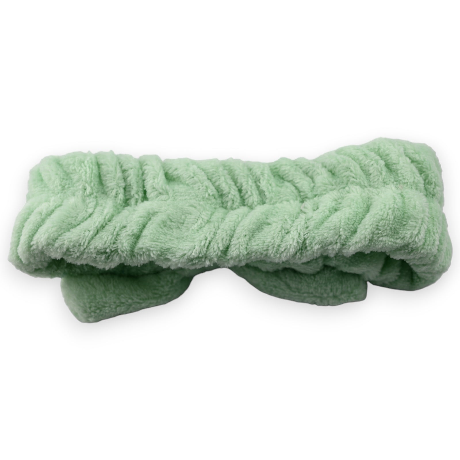 Weiches, mintgrünes Stirnband aus Plüsch für Make-up und Gesichtspflege, gefaltet auf weißem Hintergrund