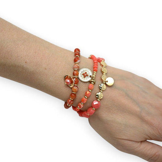 Dreireihiges Armband mit orangefarbenen und goldenen Perlen, Schmucksteinen und runder Verzierung am Handgelenk