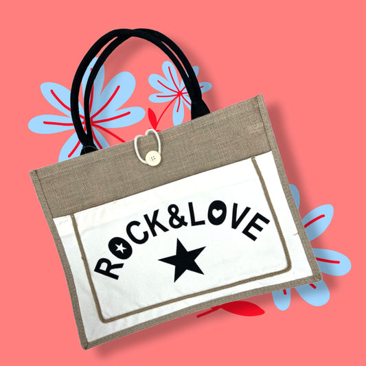 Stilvolle Einkaufstasche mit 'Rock & Love' Aufdruck und Stern, schwarze Griffe, auf rosa Hintergrund mit blauen Blumen