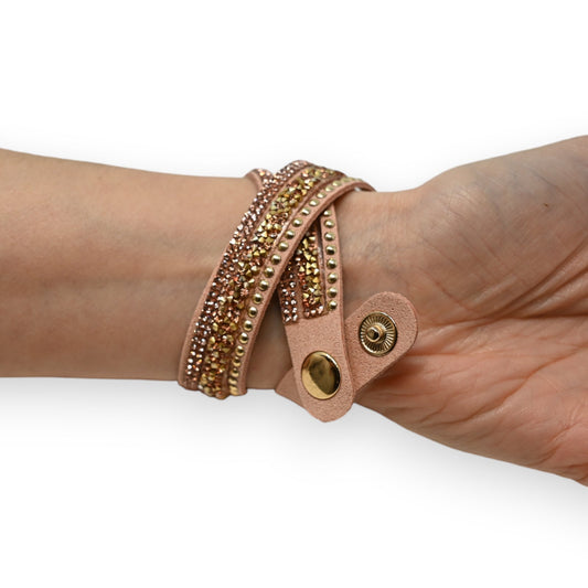 Rosafarbenes Leder-Wickelarmband mit goldenen Nieten und Strass-Steinen, am Handgelenk getragen